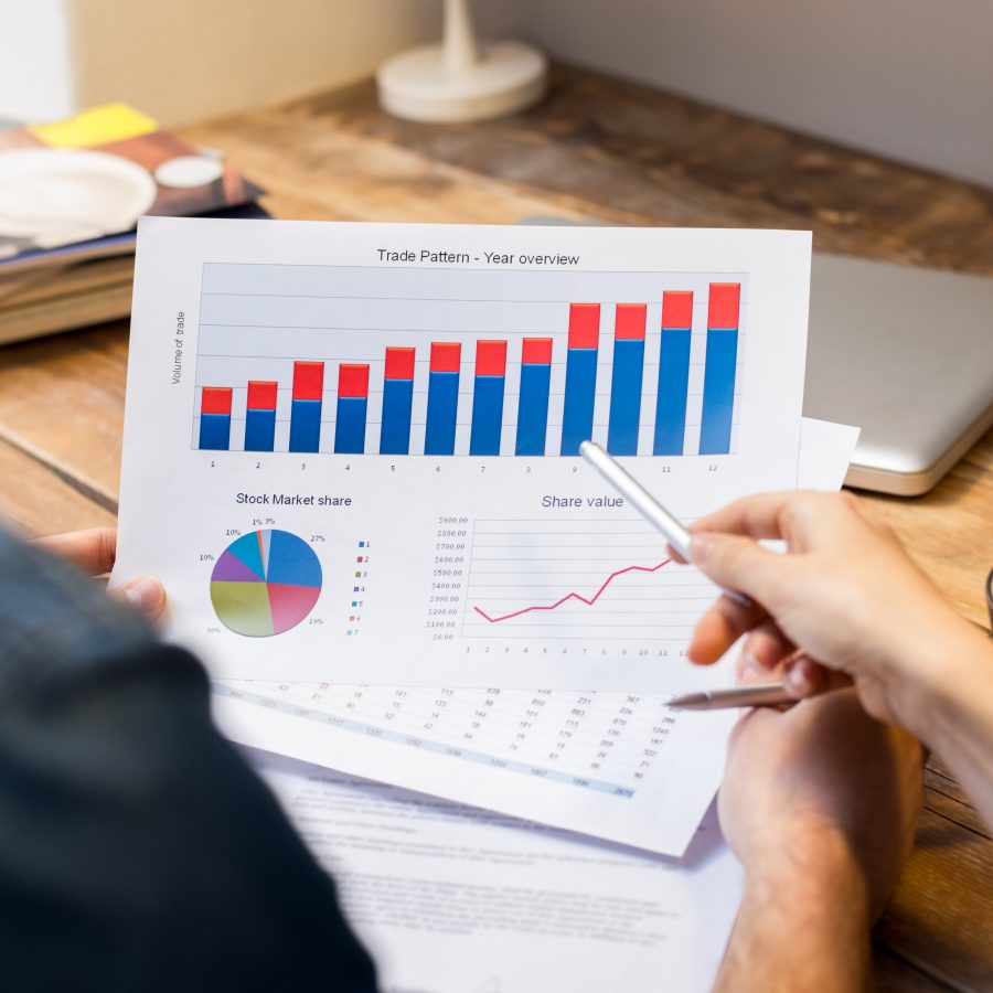 Closeup of businessman and woman discussing on stockmarket document in office
